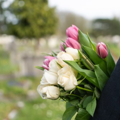 female carrying flower bouquet at a funeral