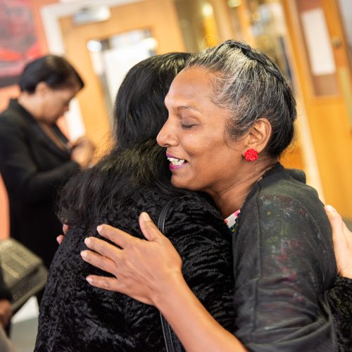 friends embrace with a hug at funeral service